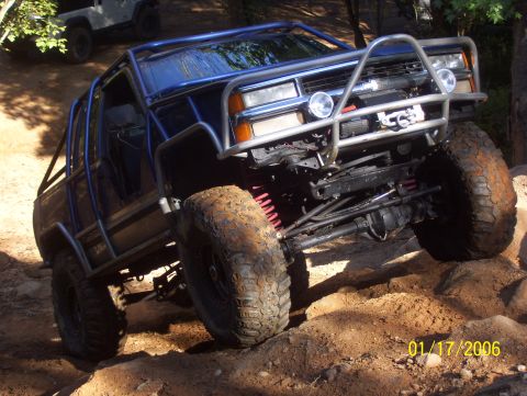 1978 Ford Bronco - This heavily modified off-road vehicle navigates a challenging rocky trail, with another vehicle in the background.