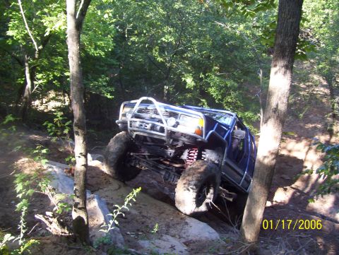 1978 Ford Bronco - A blue off-road SUV navigates a challenging rocky trail, its suspension and off-road capabilities.
