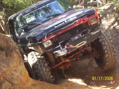 1978 Ford Bronco - This modified off-road vehicle is shown navigating a steep dirt path with large, aggressive tires.
