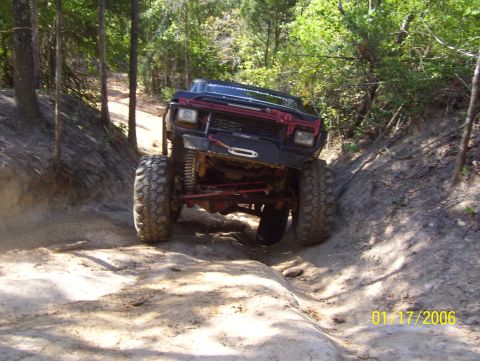 1978 Ford Bronco - This modified 1978 Ford Bronco navigates a challenging dirt path through a wooded area.