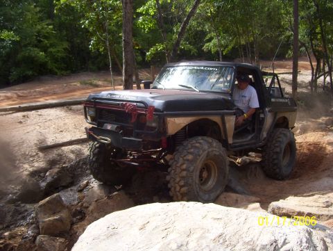 1978 Ford Bronco - Modified 1978 Ford Bronco tackling a challenging rocky trail with large tires.
