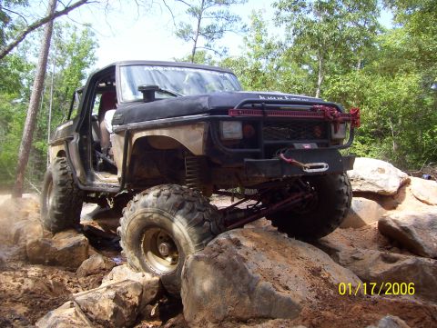 1978 Ford Bronco - Modified 1978 Ford Bronco navigating a rocky trail with large off-road tires.