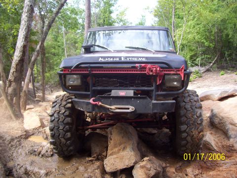 1978 Ford Bronco - Modified 1978 Ford Bronco navigating a challenging rocky trail with large tires.