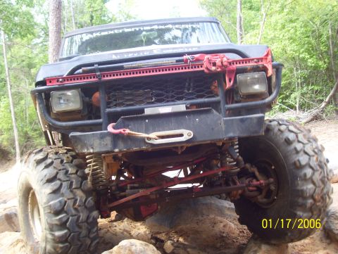 1978 Ford Bronco - This heavily modified off-road vehicle is navigating a rocky trail, its suspension and large tires.