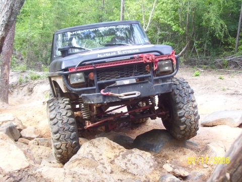 1978 Ford Bronco - Modified off-road vehicle with aggressive tires and custom front bumper tackles rocky terrain.