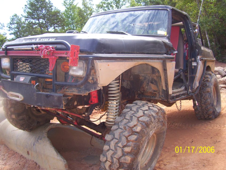 Modified off-road vehicle with large tires and a Hi-Lift jack mounted on the front bumper