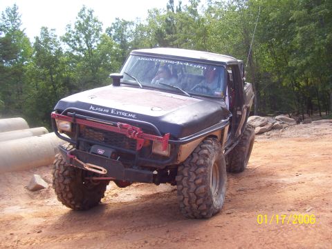 1978 Ford Bronco - Modified 1978 Ford Bronco with off-road upgrades seen on a dirt trail. "ALASKAN EXTREME" is written on the hood.