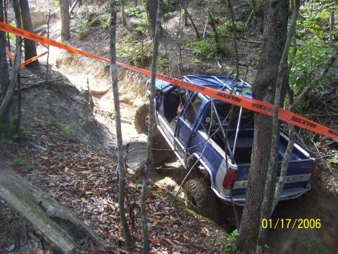 1978 Ford Bronco - This modified truck is tackling a challenging off-road course marked by orange tape.