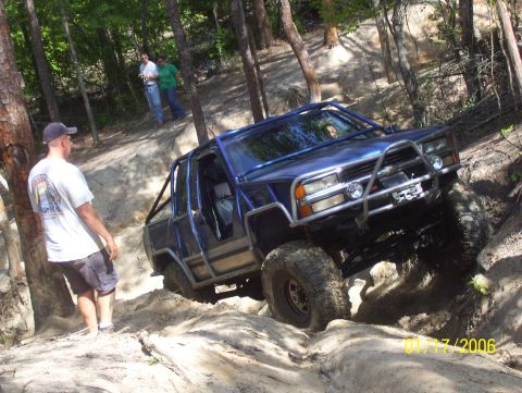 1978 Ford Bronco - Off-road vehicle navigates a challenging sandy trail with spectators observing the action.