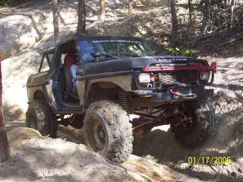 1978 Ford Bronco - This modified 1978 Ford Bronco navigates a challenging off-road trail with large tires and a lifted suspension.