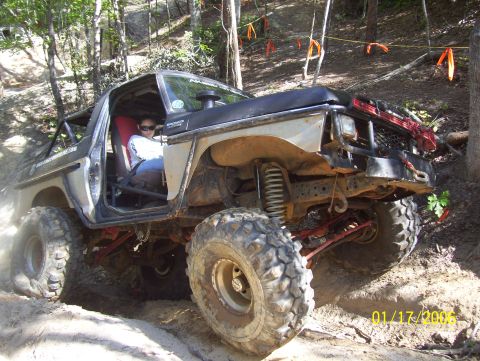1978 Ford Bronco - Off-road Bronco tackling a steep, sandy trail with visible suspension modifications.