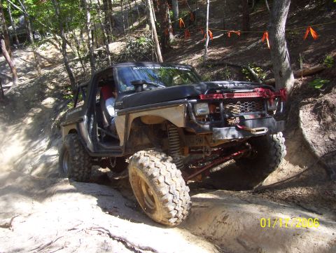1978 Ford Bronco - This modified truck navigates a challenging off-road course with steep inclines and loose dirt.