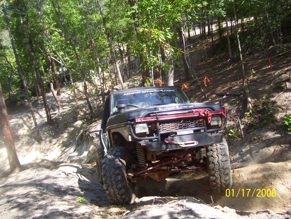 1978 Ford Bronco with red off-road bumper and winch, driving on a dirt trail