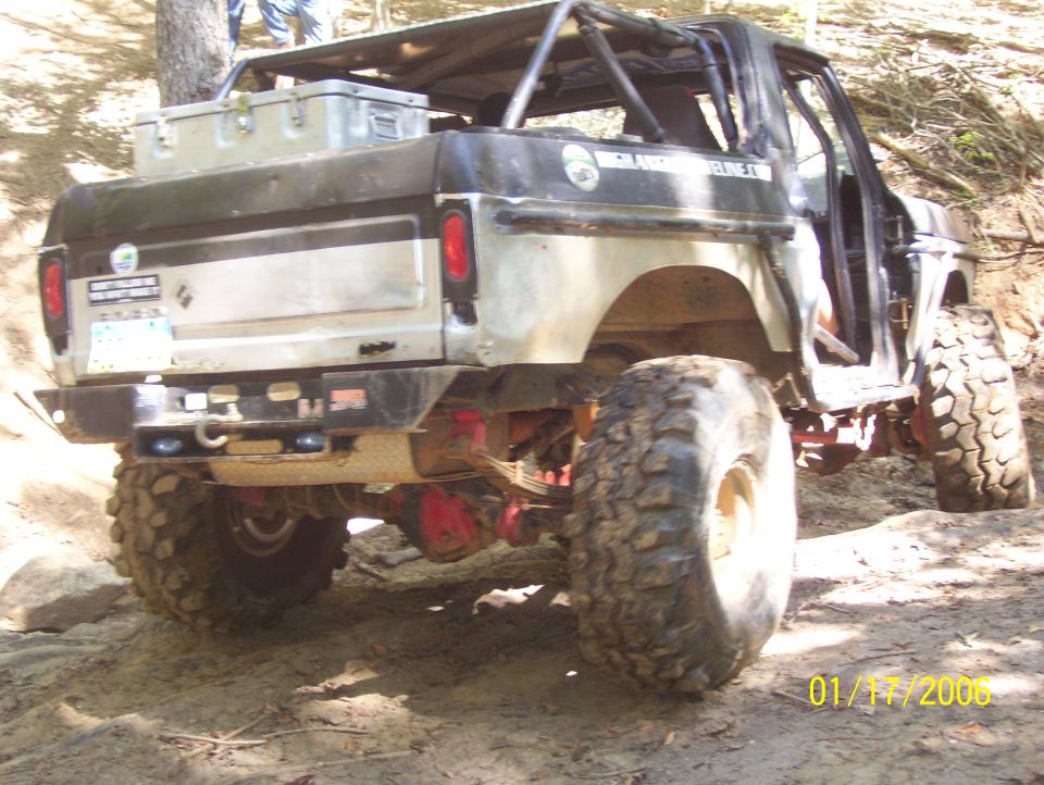 Modified SUV with large tires and roll cage, seen from rear