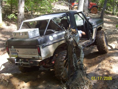 1978 Ford Bronco - Off-road Bronco stuck on a tree with another vehicle in the background.