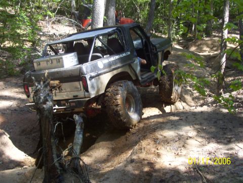 1978 Ford Bronco - This modified off-road vehicle navigates a challenging dirt path with large tires and a roll cage.