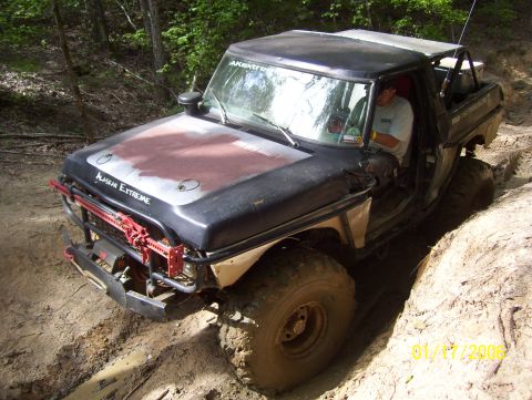 1978 Ford Bronco - Off-road pickup truck with custom modifications navigating a challenging dirt trail.