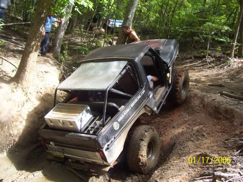 1978 Ford Bronco - This modified 1978 Ford Bronco navigates a challenging muddy trail with large off-road tires.