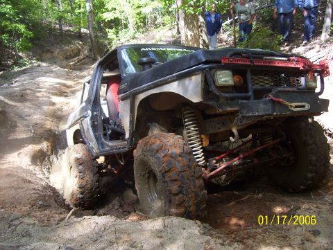 1978 Ford Bronco - This heavily modified off-road vehicle is shown struggling on a steep, muddy incline during an off-road excursion.