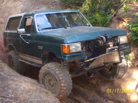 1978 Ford Bronco - This modified Ford Bronco is shown off-roading on a muddy, wooded trail.