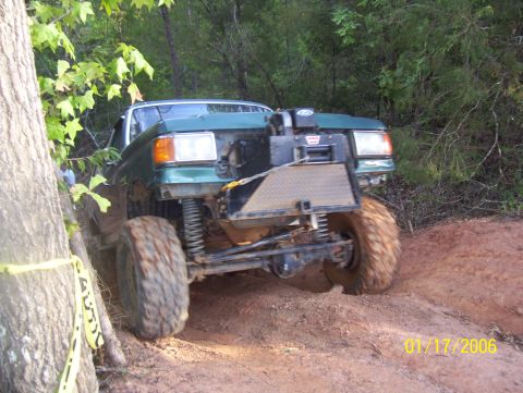1978 Ford Bronco - This modified off-road vehicle navigates a dirt trail with large tires and a prominent winch.