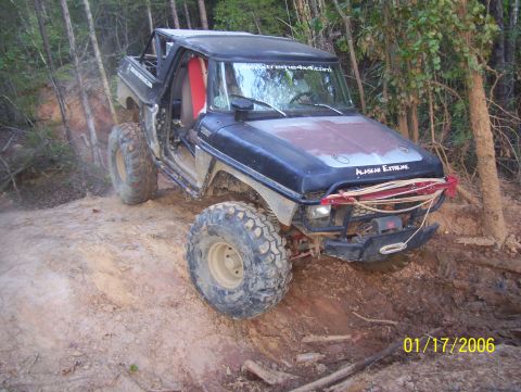 1978 Ford Bronco - Modified 1978 Ford Bronco tackling a challenging off-road course with large tires and a winch.