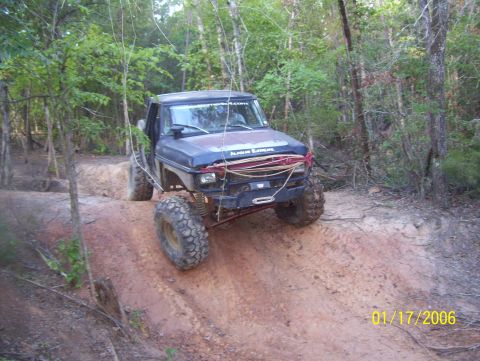 1978 Ford Bronco - This modified off-road vehicle navigates a steep dirt incline in a wooded area.
