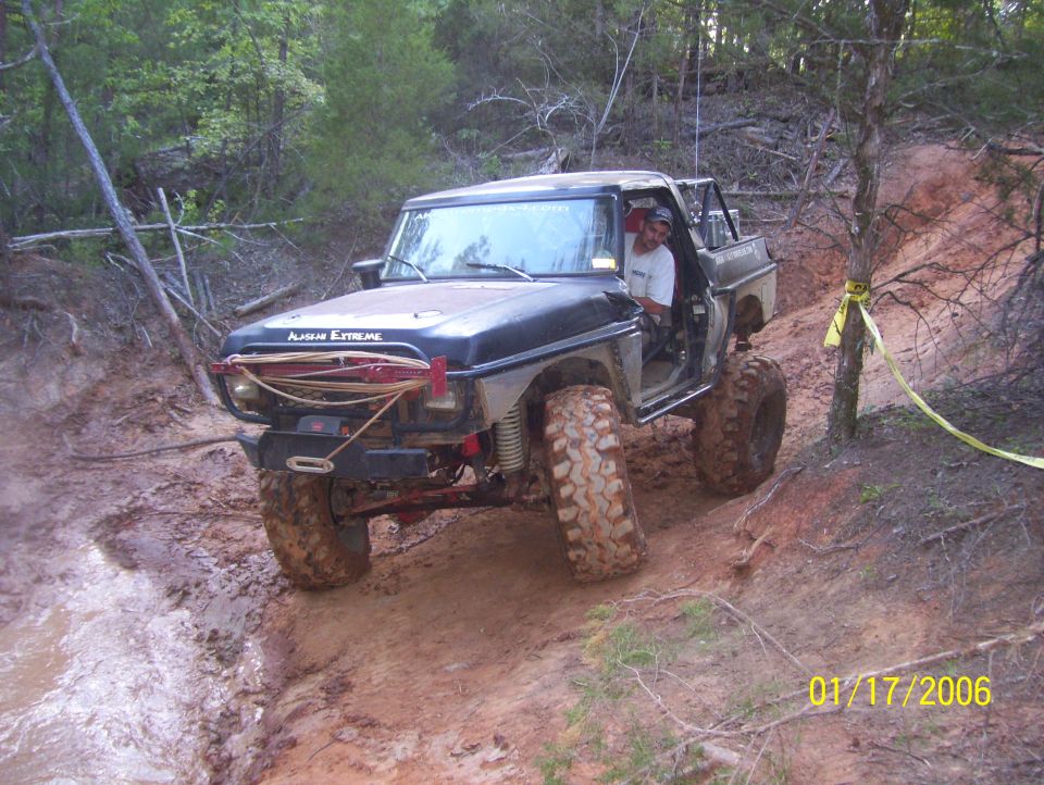 Off-road vehicle with large tires navigating a muddy trail