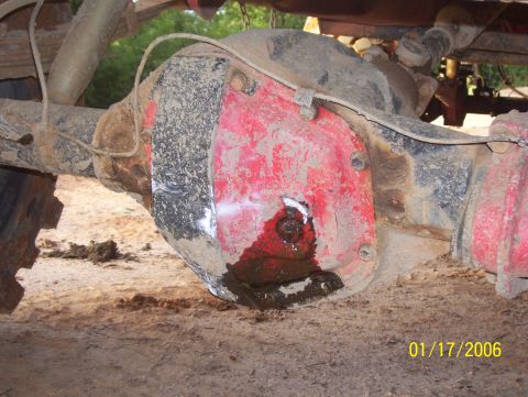 1978 Ford Bronco - A close-up view of the rear differential of a vehicle, showing a red differential cover that appears to be leaking fluid. The vehicle is co…