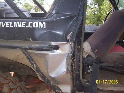 1978 Ford Bronco - A close-up view of the driver's side of a heavily modified off-road vehicle, showing a dented black body panel with the text "LIVELINE.COM"…