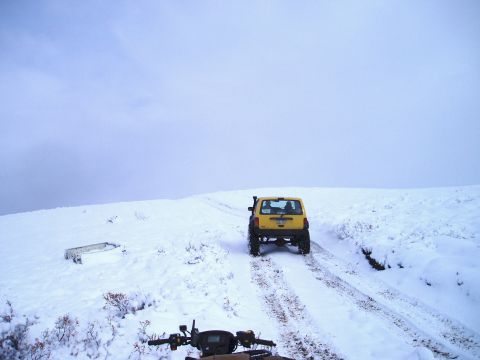 2000 Ford E350 - Two vehicles navigate a snow-covered trail under a cloudy sky.