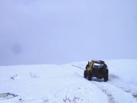 2000 Ford E350 - A yellow off-road vehicle navigates a snow-covered landscape.