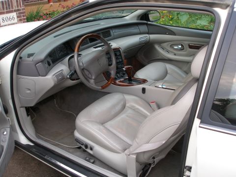 1998 Lincoln Mark VIII - The interior of a 1998 Lincoln Mark VIII shows plush leather seats and wood accents on the dashboard and steering wheel.