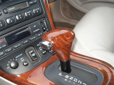 1998 Lincoln Mark VIII - Close-up of a car's center console with automatic transmission shifter and climate controls.