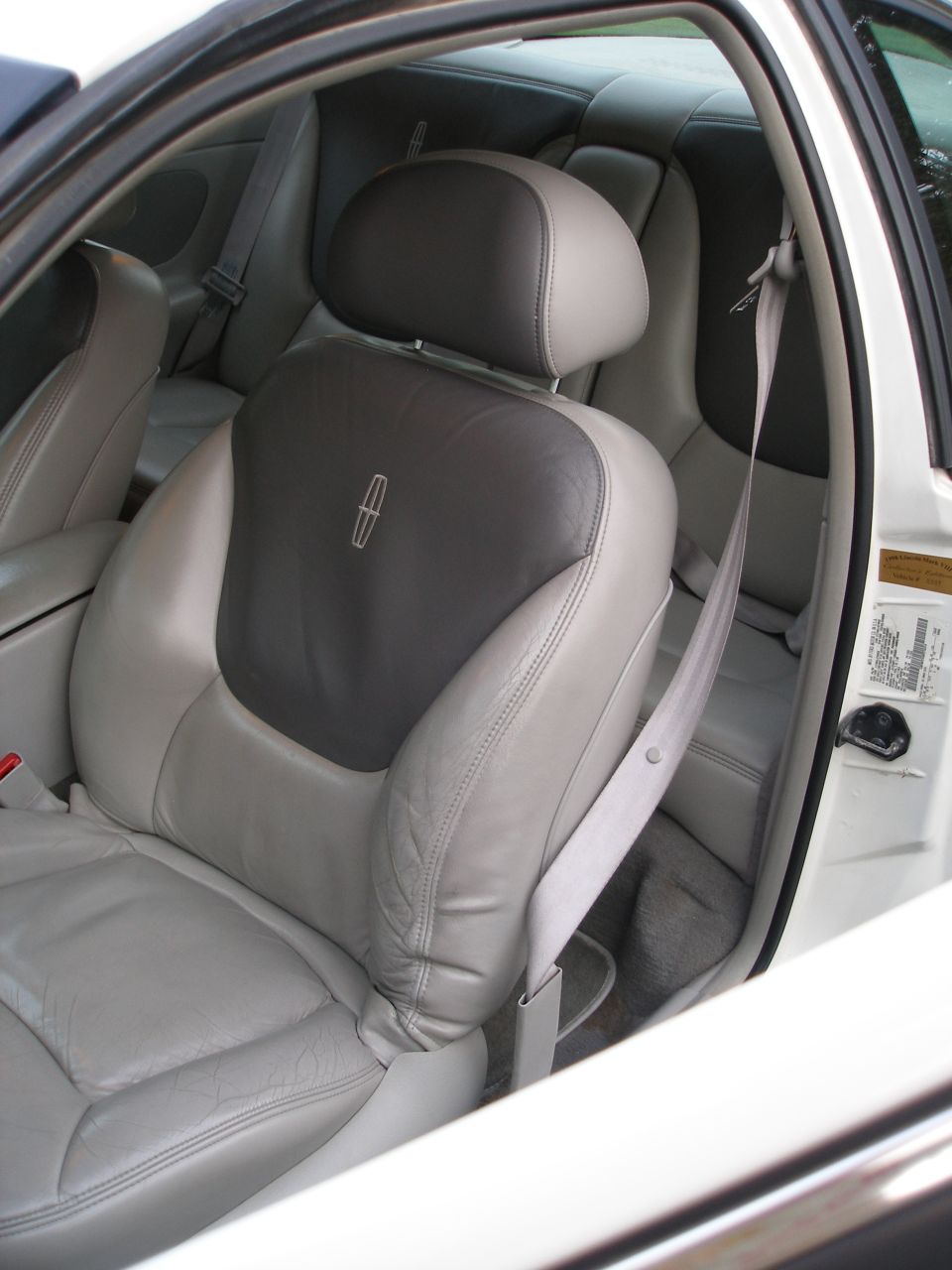 1998 Lincoln Mark VIII interior with light gray leather seats and a dark gray headrest a Lincoln emblem
