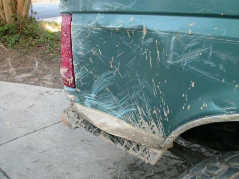 1990 Ford Bronco - The rear of a mud-splattered 1990 Ford Bronco shows damage to the bumper and body.