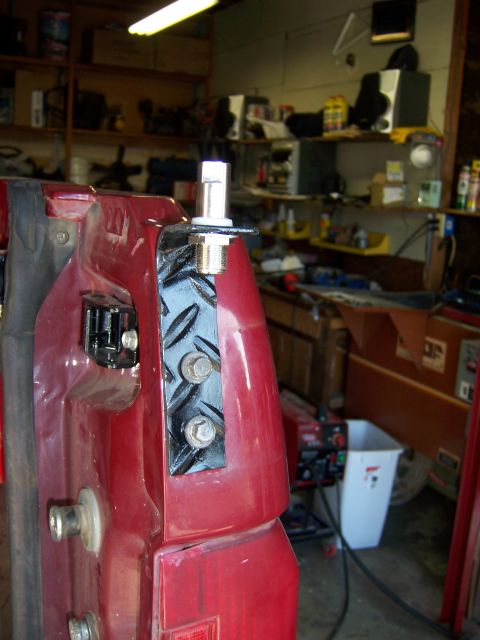 1991 Ford Bronco - Close-up of a red vehicle fender showing a CB antenna mount attached with a diamond plate bracket.