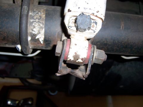 1991 Ford Bronco - Close-up of a vehicle's undercarriage showing a damaged shock absorber mounting bracket.