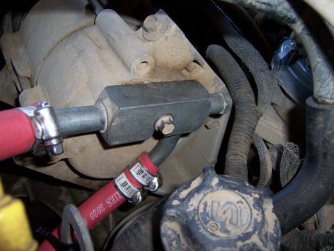 1991 Ford Bronco - Detail shot of engine bay components, including hoses secured with clamps and a central metal fitting.