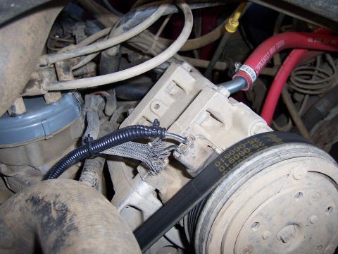 1991 Ford Bronco - Close-up view of engine components including the AC compressor and drive belt.