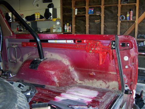 1991 Ford Bronco - High lift jack mounted inside a red vehicle, possibly a truck or SUV.