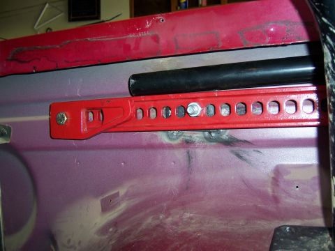 1991 Ford Bronco - A red high lift jack mount is bolted to the interior of a vehicle.