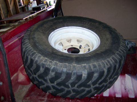 1991 Ford Bronco - A spare tire is secured in the cargo area of a red vehicle.