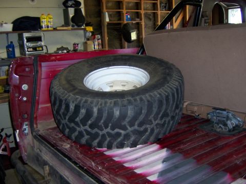 1991 Ford Bronco - Spare tire mounted in the cargo area of a red SUV.