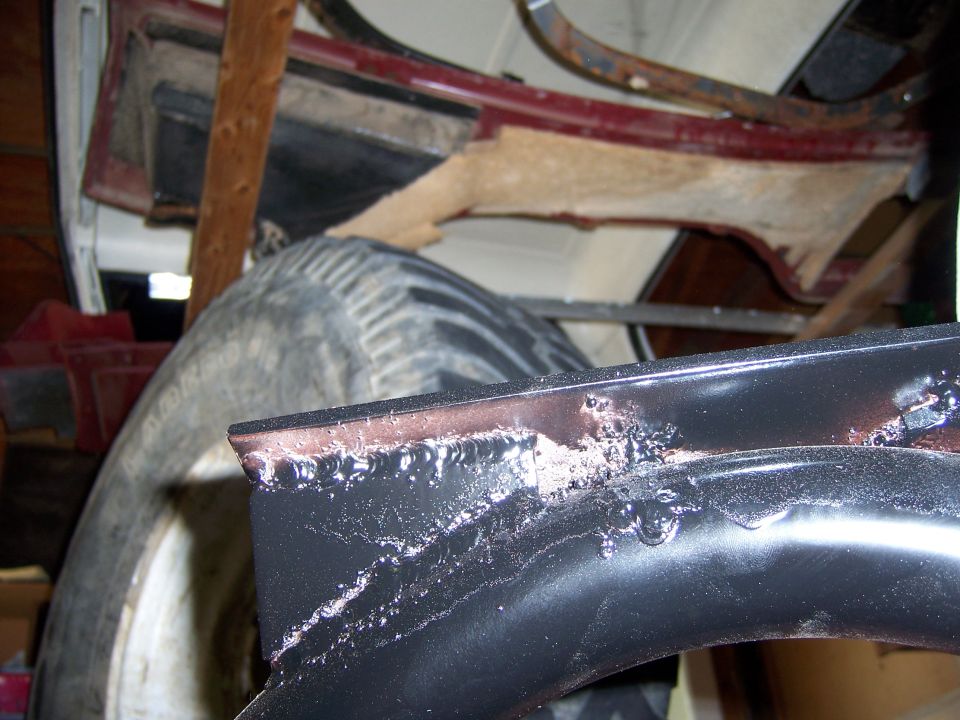 Spare tire and black metal framing with visible welds and some rust