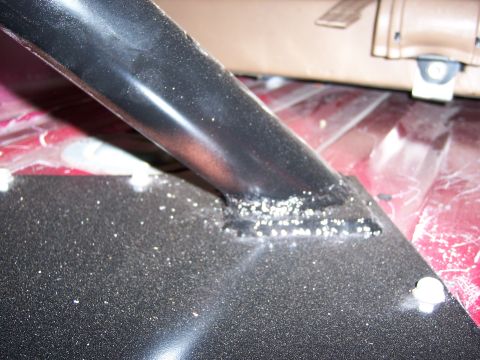 1991 Ford Bronco - Close-up of a vehicle's interior spare tire carrier mount, showing metalwork and upholstery.