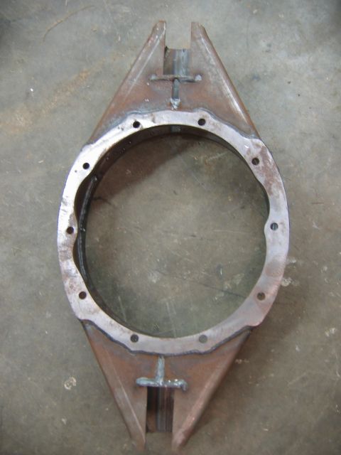 1992 Ford Mustang - This is a custom-fabricated metal component, likely for automotive or industrial use, a central bore and mounting points.