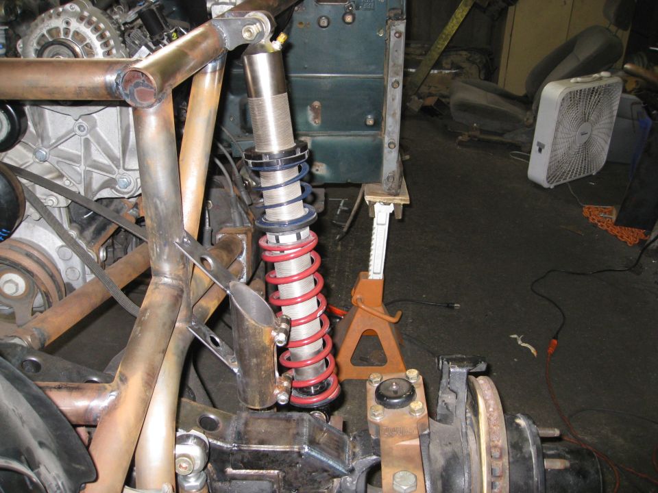 Custom suspension with red coilover shock and engine components visible