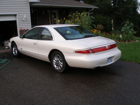 1998 Lincoln Mark VIII - A white 1998 Lincoln Mark VIII is parked in a driveway, showing its rear quarter and side profile.
