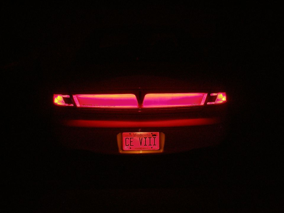 Illuminated red tail lights and Missouri license plate of car at night